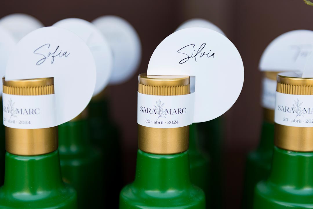 Aceite de oliva como regalo de boda: fotografía de la boda de Sara y Marc, de Mas dels Castellans. Botella de aceite con etiqueta para invitados.