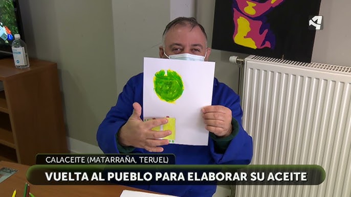 usuario de ATADI Valderrobres mostrando su dibujo para las cajas del aceite solidario de Mas dels Castellans